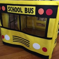 a yellow school bus shaped play tent with polka dots on the front and side windows