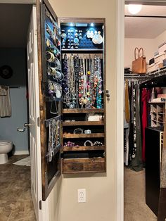 an open closet with jewelry and purses on it's shelves in a home