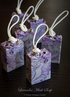 four purple and white soaps with rope tied to them