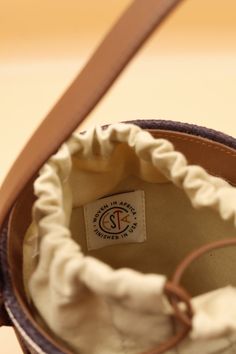 A perfect summer bucket handbag by Cesta Collective. This little pail has it all! A brown leather hand strap, a tan linen bag lining with a leather drawstring closure. Cute and petite this raffia lunch pail purse is precious and for a great cause! Each Cesta is handwoven in Rwanda, finished in Italy or USA. Luxury basket bags with a purpose. We are fans! Product Measurement Details: Height w/o straps: 6.5" Circumference: 18.5" Depth: 4.5" Damage to consider: See images in carousel of any damage. Brown Bucket Bag With Round Handle For Shopping, Brown Bucket Bag For Everyday Use, Brown Coated Canvas Bucket Bag For Everyday Use, Brown Bucket Bag With Canvas Lining For Daily Use, Brown Canvas Bucket Bag With Leather Trim, Natural Color Bucket Bag For Daily Use, Shopping Bucket Bag With Round Leather Handles, Shopping Bucket Bag With Leather Round Handles, Shopping Bucket Bag With Handles