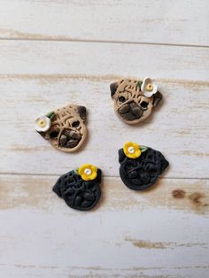 three little pug buttons sitting on top of a white wooden table next to each other