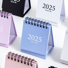 several different colored calendars sitting next to each other on top of a white table