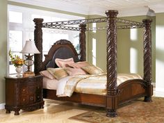 a bedroom with a canopy bed, dresser and night stand in the middle of it