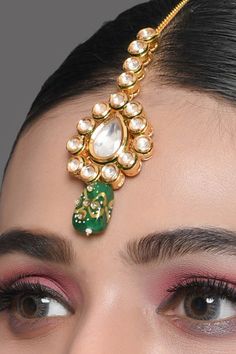 Add this Kundan mang tika to your jewellery collection and shine at the next ethnic event. Embellished with beads, it is truly a stunning piece to flaunt this season. Product Features: Color: Kundan Gold toned green beaded Mang tika Material: Metal copper alloy,semiprecious tanjore beads work : kundan with meenkari on back side Dimension: Length 5.9 in, width -1.5 in Pack Of: Mang tika Occasion: festive and wedding Disclaimer: There will be slight difference in digital to actual image Mang Tika, Beads Work, Green Bead, Jewellery Collection, Dia De Muertos, Bead Work, Product Features, Semi Precious, Ear Cuff