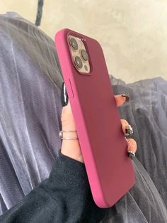 a woman is holding up her phone case