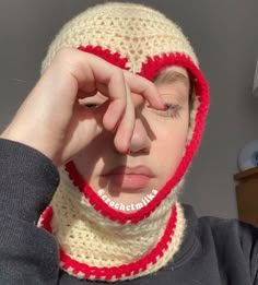 A girl wearing a cream coloured heart cut out crochet ski mask with red lining on the rim of the heart cut out and as well as the opening to the mask. Crochet Heart Balaclava, How To Crochet A Ski Mask, Bonnet Pattern Crochet, How To Style Balaclava, Free Crochet Pattern Chunky Yarn, How To Crochet Balaclava, Crochet Heart Hat, Crochet Mask Pattern Free