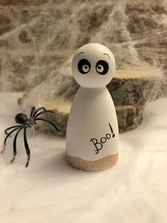 a wooden toy with the word boo on it next to a spider