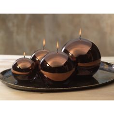 three candles sitting on top of a black plate