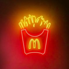 a neon sign that says mcdonald's with french fries in the bottom right corner