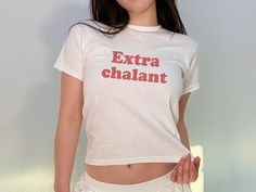 'Extrachalant' Baby Tee The model in the main image is 5'1 and is wearing an XS.  She is 105lb, chest 33C - typically wears an XS - Trendy Y2K Baby tee style for adults - This is a 90s style Baby tee which runs true to size (please see size chart) - 100% cotton (180 g/m²) Our main production is in California, US but we ship from distribution hubs located around the world including Canada, UK & Australia to reduce shipping time.  If your country isn't currently listed, please reach out and we'll White Y2k Style Stretch T-shirt, White Stretch Y2k T-shirt, Y2k White T-shirt With Funny Text, White Y2k T-shirt With Funny Text, Baby Tees 90s, Funny Baby Tees, Style Année 90, 90s Tshirt, Baby Tees Y2k