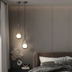 a bed with two lights hanging from the ceiling above it and a night stand next to it