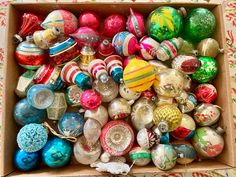 a box filled with lots of different colored ornaments