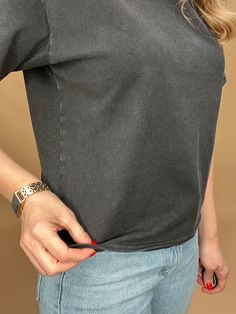 This black mineral washed tee features a slight crop and a raw bottom hem, creating an effortless look that hits at the top of the hips. Perfectly paired with denim for a stylish and comfortable outfit. Details: Slightly cropped fit Raw bottom hem Fit: true to size, Amber is modeling size Small. Contents: 100% Cotton Imported. Casual Everyday T-shirt With Frayed Hem, Casual Cotton T-shirt With Frayed Hem, Trendy Washed Black T-shirt, Relaxed Fit Short Sleeve T-shirt With Frayed Hem, Relaxed Fit T-shirt With Frayed Hem, Black Stonewashed Short Sleeve Tops, Relaxed Washed T-shirt, Casual Washed Black Stonewashed Top, Casual Stonewashed Washed Black Top