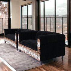 a living room filled with black couches next to large windows and wooden flooring