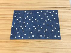 a piece of cloth with white stars on it sitting on top of a wooden table