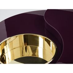 a purple and gold bowl sitting on top of a table