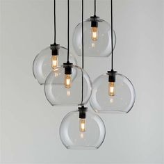 four clear glass globe lights hanging from the ceiling