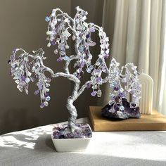 a bonsai tree sitting on top of a table next to a vase filled with rocks