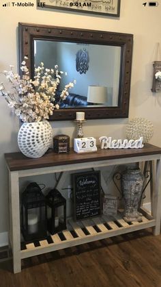 the entryway is decorated with white flowers and decorative items, along with a framed mirror