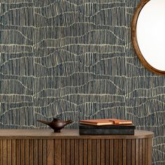 a wooden cabinet with a mirror on top of it next to a wallpaper design