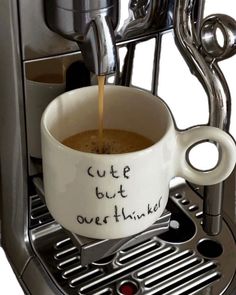 a cup of coffee is being filled with liquid from an espresso machine that says cute but overthiled