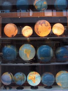 there are many globes on display in the case