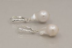 "Natural color baroque pearl drop earrings in sterling silver. These pearls are a very nice quality with a \"pearly white\" color. The surface is smooth with some luster and a very defined \"baroque shape\". They are the \"perfect\" size and well paired. Earrings hang 1.5\" long on sterling silver lever backs with front shields. You will receive the exact pearls pictured. One of a Kind! Materials: freshwater baroque shape pearls 18mm x 10mm sterling silver lever backs INTERNATIONAL CUSTOMERS: Cu White Pearl Clip-on Earrings, White Pear-shaped Pearl Pendant Earrings, White Pear-shaped Pearl Earrings With Pendant, White High Luster Drop Pearl Earrings, White Drop Pearl Pendant Earrings, White Drop Pearl Earrings With Pendant, Silver Briolette Pearl Earrings For Anniversary, White Baroque Pearl Earrings For Formal Occasions, Formal White Baroque Pearl Earrings