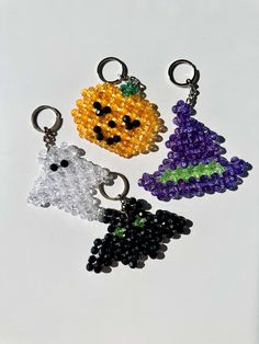 four halloween beaded key chains with pumpkins, ghost and witch faces on them