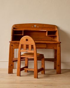 a wooden desk and chair sitting next to each other