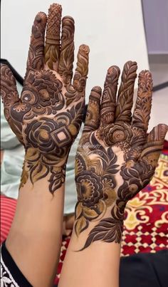 two hands with henna designs on them