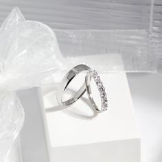 two wedding rings sitting on top of a white box