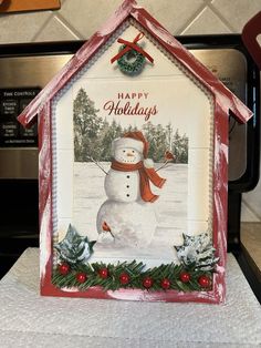 a house shaped card with a snowman on it