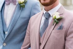 two men in suits with boutonnieres and flowers on their lapel jackets