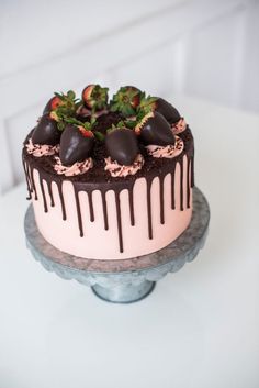 a chocolate covered cake with strawberries on top and drizzled in chocolate