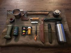 an assortment of camping items laid out on a blanket