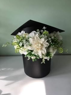 a black graduation cap with white flowers in it