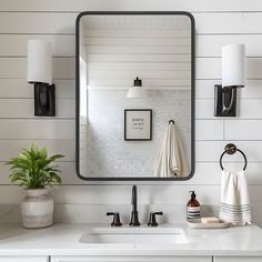 a bathroom sink with a mirror above it and two lights on the wall behind it