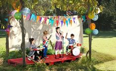 children are playing music under the party decorations