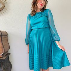 "Fantastic late 70s to 80s vintage dress in vibrant teal green blue. Love the gorgeous voluminous sheer sleeves, ruffled tiered neckline, elastic waist, and crimp pleated skirt with funky texture toward the hem flares out to A-line shape. So light, and floaty with tons of movement and playful details! Vintage made in the USA by the brand Jenny. Has string belt loops but missing original belt. Tagged size 12, suits about a modern medium. Measures Bust, pit to pit 20\"  Elastic waist 12\" relaxed Vintage Long Sleeve Pleated Midi Dress, Spring Billowy Midi Dress For Party, Spring Party Vintage Pleated Dress, Fall Party Dresses With Accordion Pleats, Spring Vintage Pleated Midi Dress, Long Sleeve Midi Dress With Accordion Pleats For Party, Fall Fitted Midi Dress With Accordion Pleats, Fitted Midi Dress With Accordion Pleats For Fall, Fitted Dress With Accordion Pleats For Fall