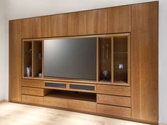 a large entertainment center with wooden cabinets and a flat screen tv on it's side