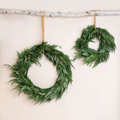 two green wreaths hanging on a wall