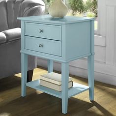 a blue end table sitting on top of a hard wood floor next to a couch