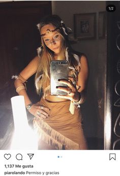 a woman in native garb holding a cell phone