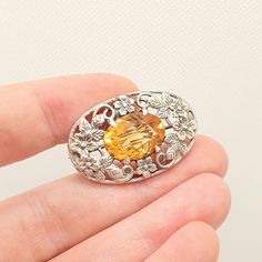 DESCRIPTION: A rare genuine antique Bernard Instone sterling silver brooch, adorned with a natural citrine gemstone. I'm confident this brooch is a genuine piece due the the age, style, craftsmanship and lack of hallmarks. The brooch is simply stamped "STERLING SILVER" which is how Bernard Instone marked his jewellery. The brooch weighs approx. 9.30g and the size dimensions are in the later photos. PLEASE NOTE: The citrine has a small chip to its edge, see pictures/video. Mountains of unique ant Vintage Silver Brooch With Gemstone, Vintage Silver Gemstone Brooch, Oval Gemstone Brooches For Anniversary, Antique Oval Gemstone Brooch, Antique Oval Gemstone Brooches, Silver Oval Gemstone Brooch, Silver Oval Gemstone Brooches, Oval Gemstone Brooch For Gift, Jewelry Post