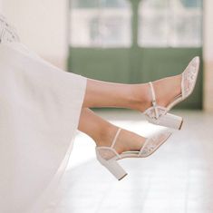 a woman's legs in high heels and a white dress