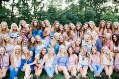 a group of women sitting next to each other on top of a lush green field