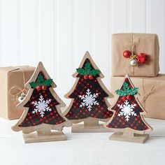 three small wooden christmas trees with snowflakes on them