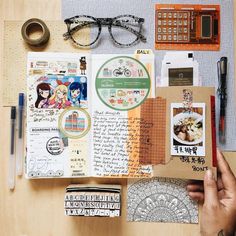 an open book with various stickers and other items on the table next to it