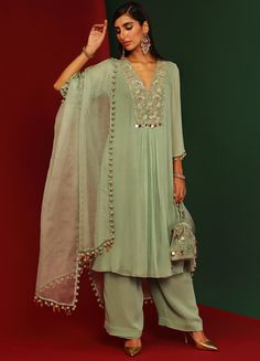 Features a jade georgette kurta with sequin work velvet yoke and 3D embellishments at the hem. This V-neck kurta has circular tassels on the sleeves hem. Paired with hem tasseled dupatta. An ideal indo western pick for Mehendi and wedding guests. Composition : Kurta and Pants: Georgette, Dupatta: Organza, Lining: Shantoon Care: Dry Clean Only and Vacuum Storage All products can be customised for sleeves, length of blouse and neck design Delivery : 4-6 weeks as the product is hand crafted. Check Georgette Kurta Sets For Women, Mahima Mahajan, Lehenga Style Saree, Indian Bridesmaid Dresses, Color Jade, Indian Wedding Wear, Straight Kurta, Organza Dupatta, Kurta With Pants