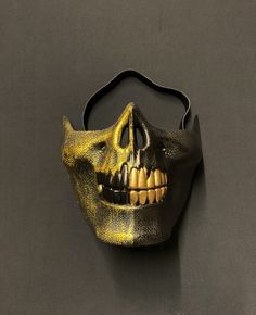 "This zombie half skull mask is hand painted in a brushed gold and solid black. Mask has unique style with raised detail and two-tone colors. Also, this mask is lightweight and has a foam backing and elastic band for a comfortable fit. Great addition to any Halloween zombie or skull style costume. Size 6.5\"W x 5.5\"H" Black Halloween Mask For Protection, Black Mask For Halloween Protection, Black Protective Mask For Halloween, Gold Halloween Costume Mask, Black Full Face Horror Mask, Black Horror Full Face Mask, Black Skull Shaped Mask For Masquerade, Black Skull Mask For Masquerade, Black Skull Mask For Halloween